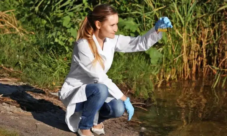 A képen a vízügyi technikus vesz mintát a tóból vagy folyóból.