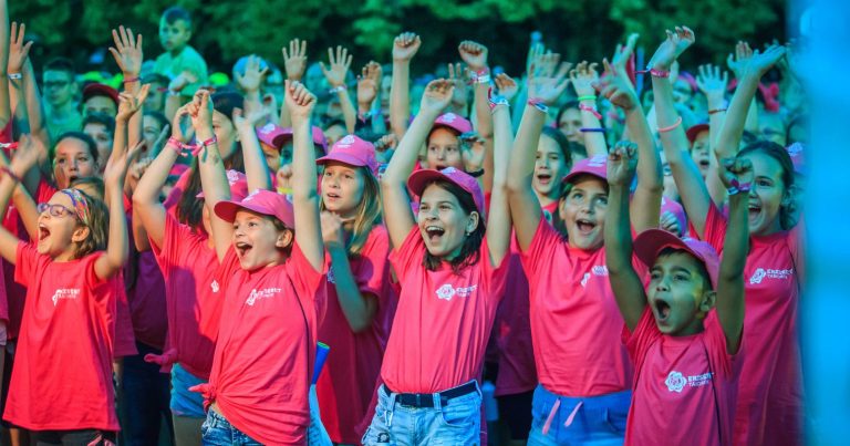 Erzsébet-táboros gyerekek rózsaszín sapkában és pólóban ujjonganak.